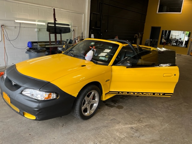 Yellow Ford Mustang with custom black vinyl hood graphics applied by 2Shady Tinting