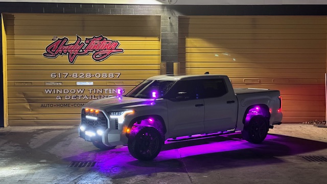 Pickup truck with installed LED underglow lighting outside the 2Shady Tinting shop
